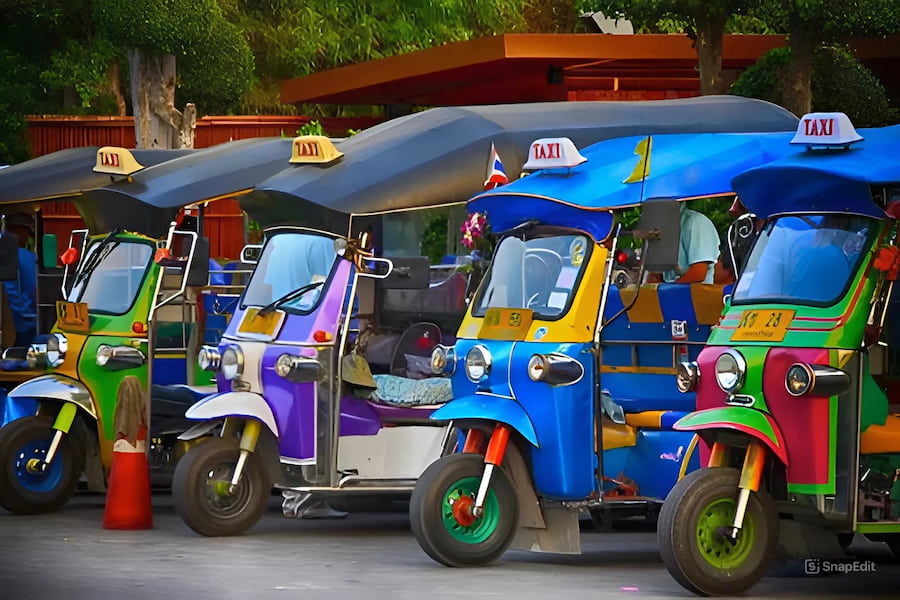 Un colorato tuk-tuk tradizionale sfreccia per le strade trafficate di Bangkok.