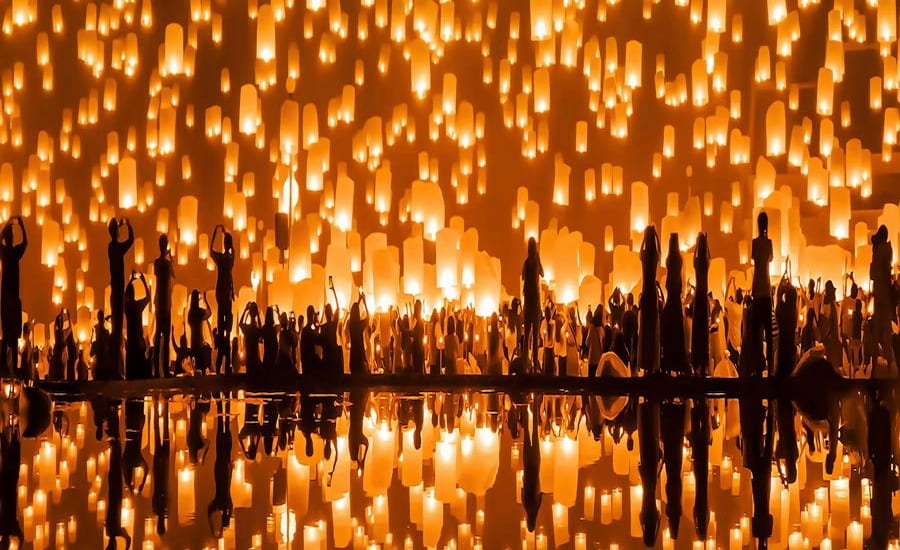 Migliaia di lanterne luminose che fluttuano nel cielo notturno di Chiang Mai